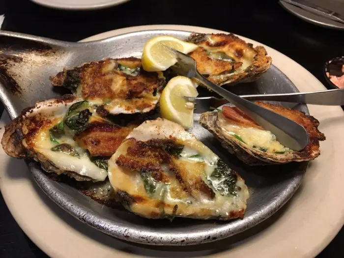 Oyster Rockefellers dish served on the plate with lemons
